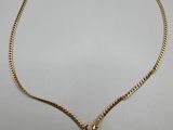 un collier en or avec un pendentif en perle au bout d'une chaîne
