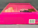 barbie doll in a pink box on a gray surface