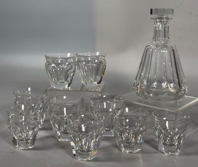 Des bouteilles et des verres sont alignés sur une table à côté d'une carafe à vin.