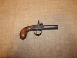 un gros plan sur un petit pistolet posé sur un tissu marron