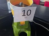 a green blender sitting on a counter with a sign on it