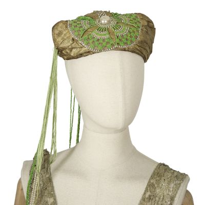 an image of a mannequin headpiece with a green and gold design