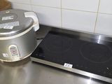 a stove top with a pot on it and a box on the counter