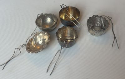 cinq cuillères en argent posées sur une surface blanche