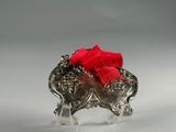 silver elephant with a red bow on its head on a clear acrylic stand