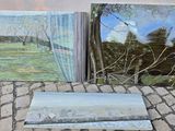 deux tableaux représentant des arbres sont posés sur un sol pavé