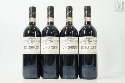 quatre bouteilles de vin rouge sont alignées sur une table