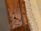 a close up of a wooden chair with peeling paint on it