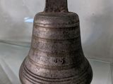 une cloche en métal exposée dans une vitrine