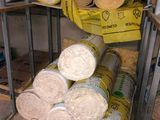 une pile de rouleaux de tissu enroulés à côté d'une pile de rouleaux enroulés