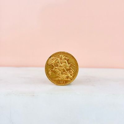 a gold coin sitting on top of a white surface