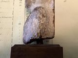 a statue of an owl sitting on top of a wooden stand