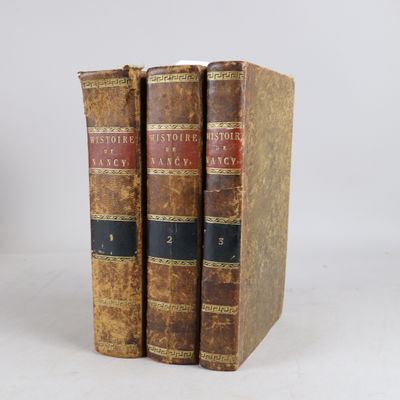 two old books sitting on top of each other on a white surface