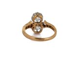 a close up of a gold ring with two diamonds on it