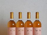 quatre bouteilles de vin posées sur une table en bois