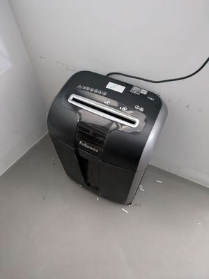 a black and silver paper shredder sitting in a corner