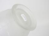 a glass vase with a lid on a white surface