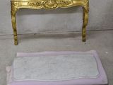 une table dorée et un tapis rose au sol