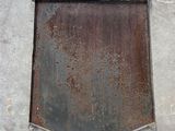 a rusted window on the side of a concrete building