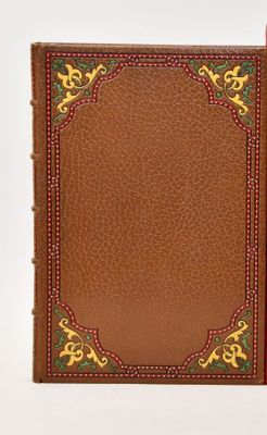 un vieux livre à la couverture rouge posé sur une surface blanche