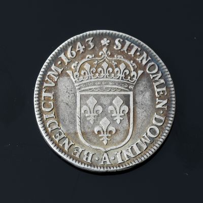 a close up of a silver coin with a crown on it