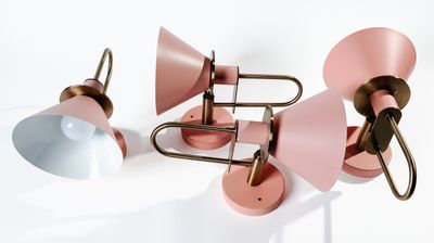 deux lampes roses et blanches posées l'une à côté de l'autre sur une surface blanche