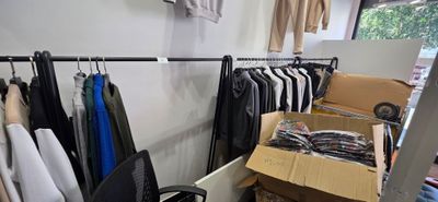 beaucoup de vêtements suspendus à une étagère dans une pièce