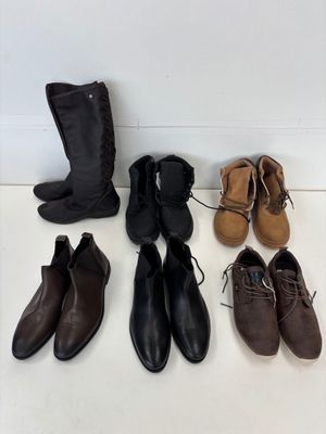 Plusieurs paires de chaussures sont alignées par terre