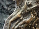 a bronze statue of a woman holding a child
