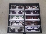 many pairs of glasses in a box on the floor