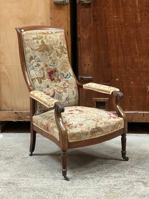 une chaise dont l'assise est recouverte d'un tissu à motifs floraux, placée devant un meuble