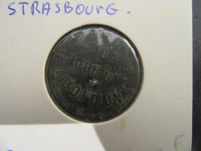 une petite pièce posée sur un bout de papier sur lequel il y a quelque chose d'écrit