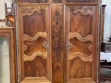 an antique wooden armoire with a glass door and a mirror