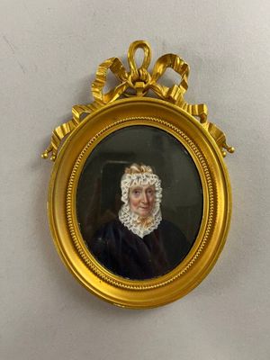 portrait of a woman in a black dress in a gold frame on a white wall
