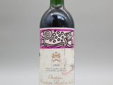 une vieille bouteille de vin posée sur une table blanche