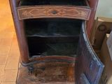 a small wooden cabinet with a door open on the floor