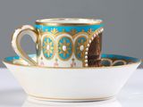 a cup and saucer sitting on a white table