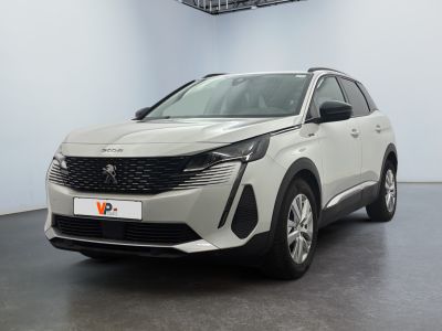 La voiture blanche est garée dans une grande pièce au sol noir.