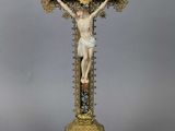 a statue of jesus on the cross with a cross in the background