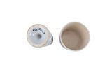 a cup and a saucer sitting next to each other on a white surface