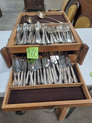 a lot of silverware on a table with a price tag