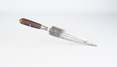 un vieux couteau au manche en bois posé sur une surface blanche
