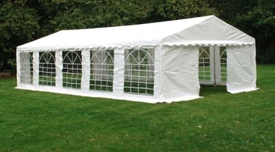 a white tent with windows in the middle of a grassy field