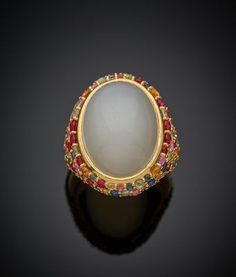 un gros plan d'une bague ornée d'une pierre blanche entourée de pierres multicolores