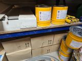 several buckets of yellow paint on a shelf in a room