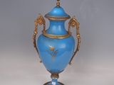 a blue vase with a gold decoration on the top of it