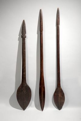 three wooden spoons and a knife on a white surface
