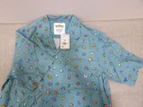 blue shirt with cartoon characters on it sitting on a couch