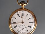 a gold pocket watch with roman numerals on the face