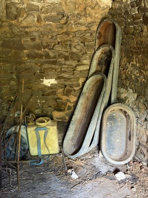 un tas de vieilles toilettes dans une pièce aux murs en pierre